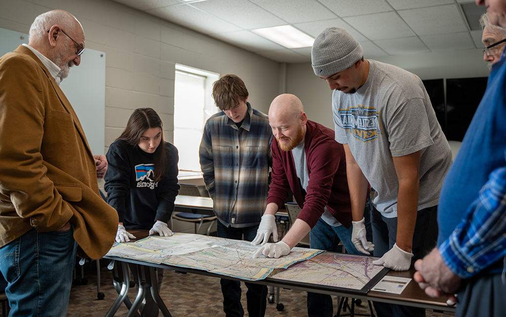 Students around a table studying a map